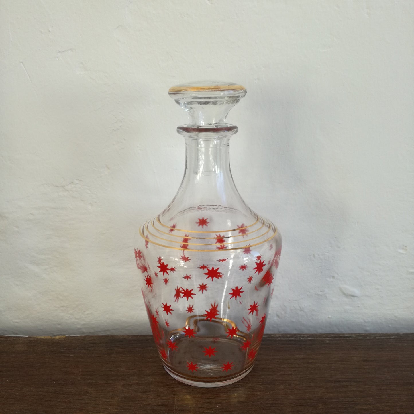 Petite carafe à liqueur en verre à décor d'étoiles rouges et cercles dorés