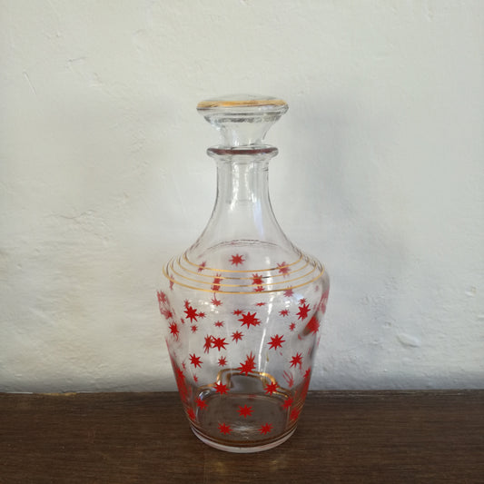 Petite carafe à liqueur en verre à décor d'étoiles rouges et cercles dorés