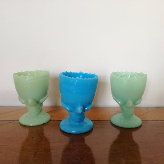 3 coquetiers en opaline bleu clair et verte à décor de poule portant l'œuf sur ses ailes