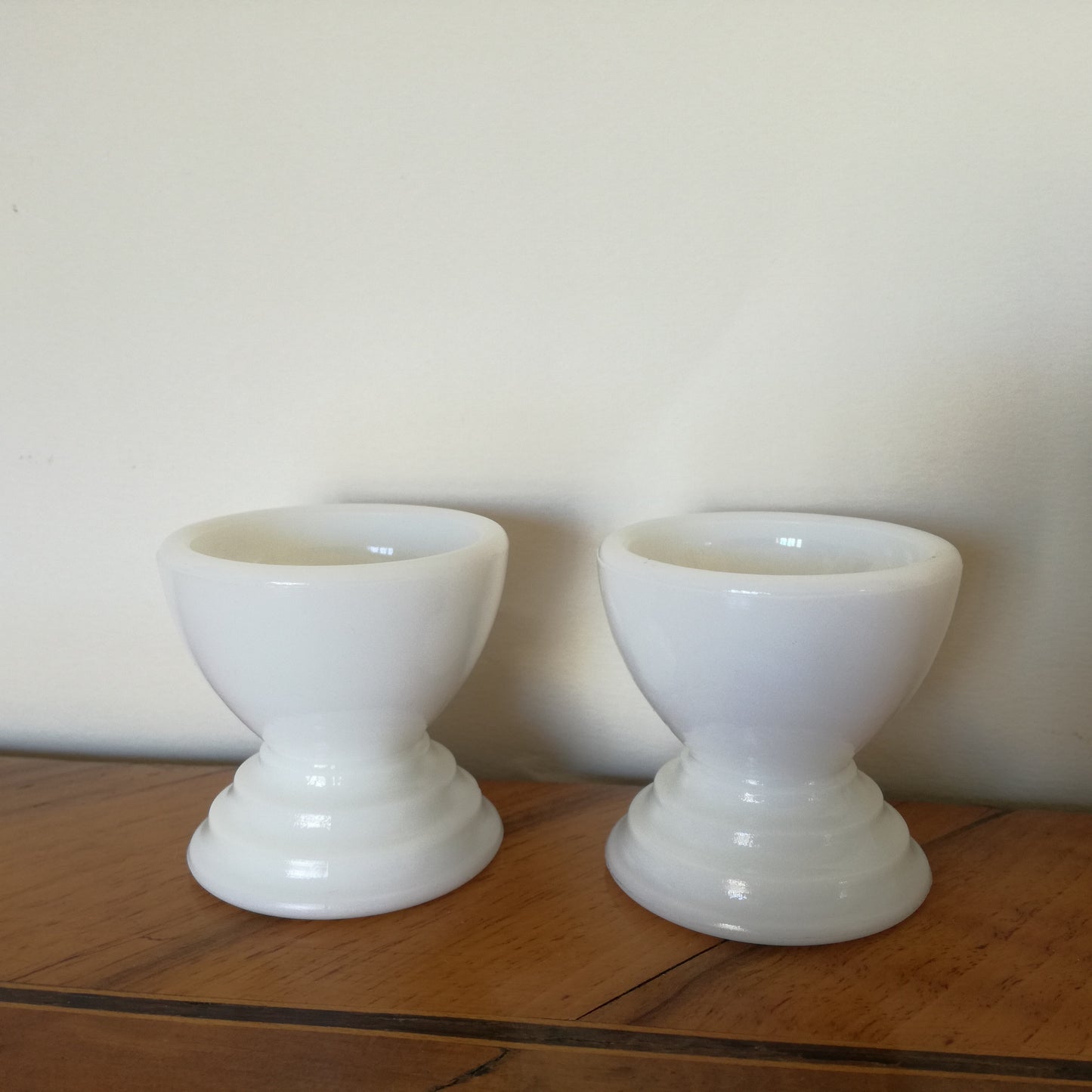 Duo de coquetiers en opaline blanche, pied à gradin ou spirales