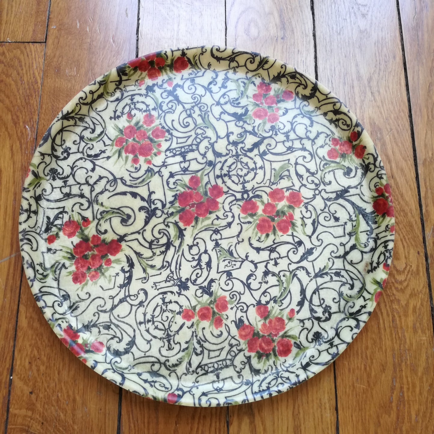 Plateau rond ancien en fibre de verre à décor d'arabesques noires et fleurs rouges
