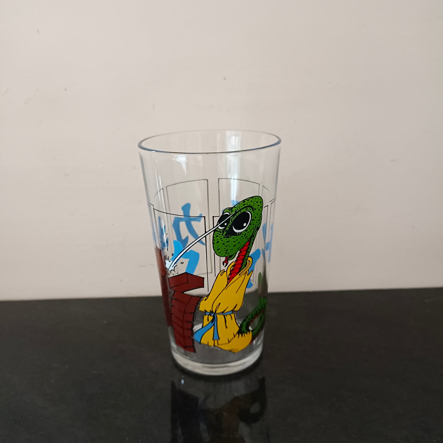 Grand verre à eau décor de serpent cassant des briques, VMC France Reims