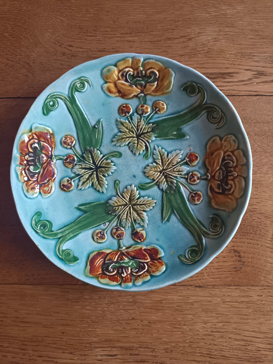 Assiette bleue en barbotine à fleurs de couleur jaune et orange
