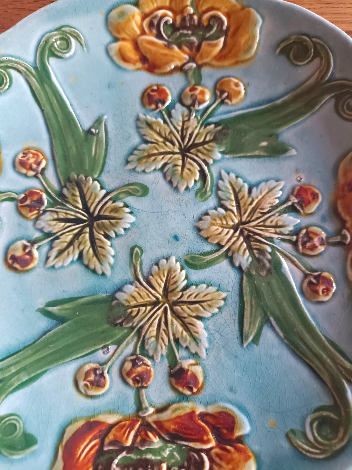 Assiette bleue en barbotine à fleurs de couleur jaune et orange