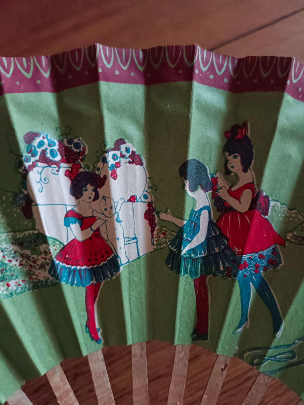 Éventail en papier et bois vers 1930 à décor de jeunes filles dans un décor bucolique