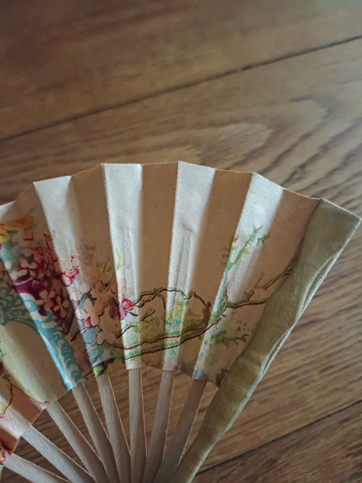 Petit éventail en papier et bois vers 1930 à décor de jeune femme au bouquet