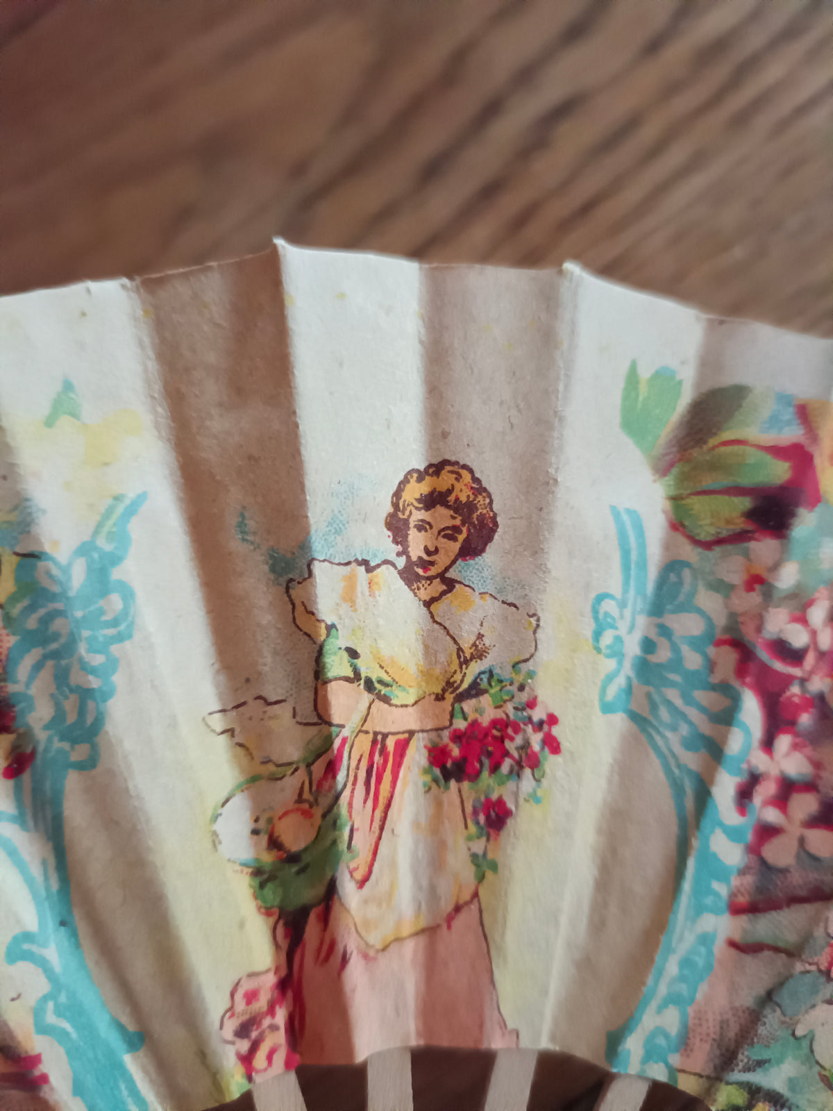 Petit éventail en papier et bois vers 1930 à décor de jeune femme au bouquet